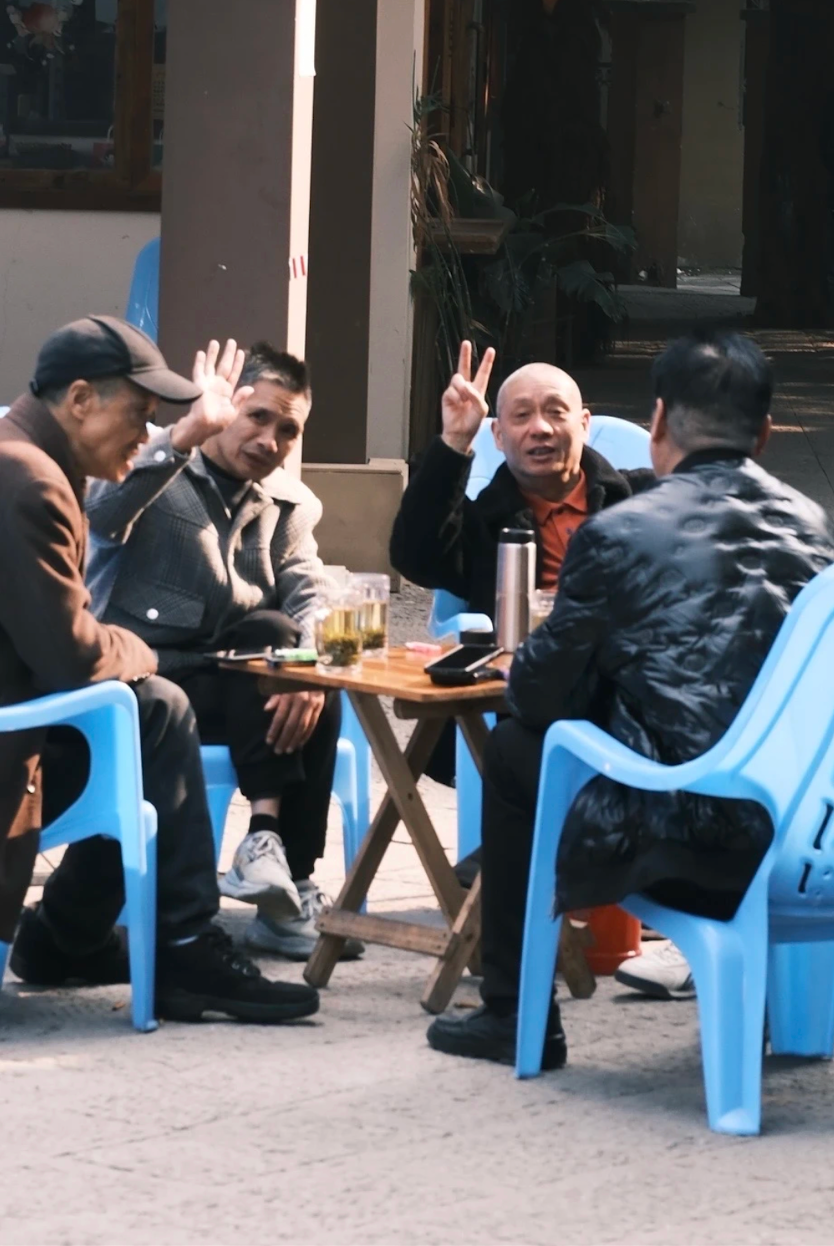 Neighbors sharing tea around a small table in a Chongqing courtyard