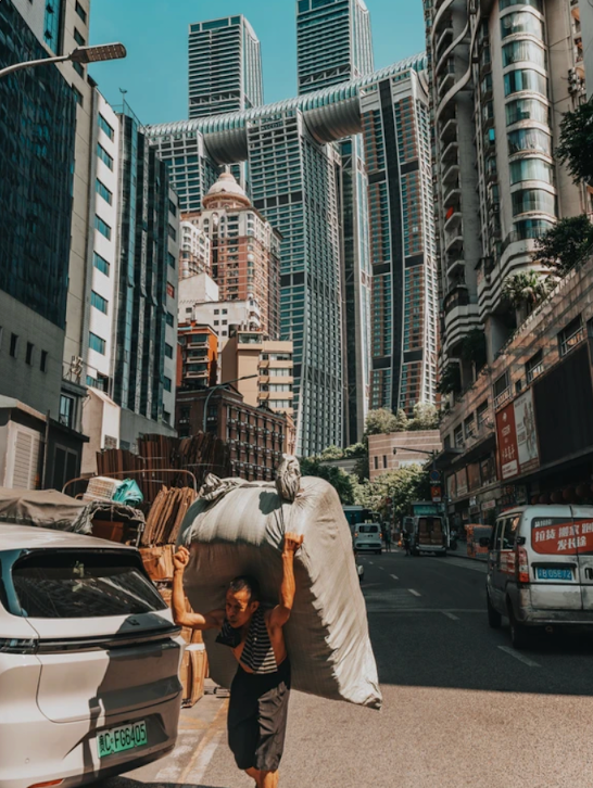 A porter carrying goods through a steep Chongqing street